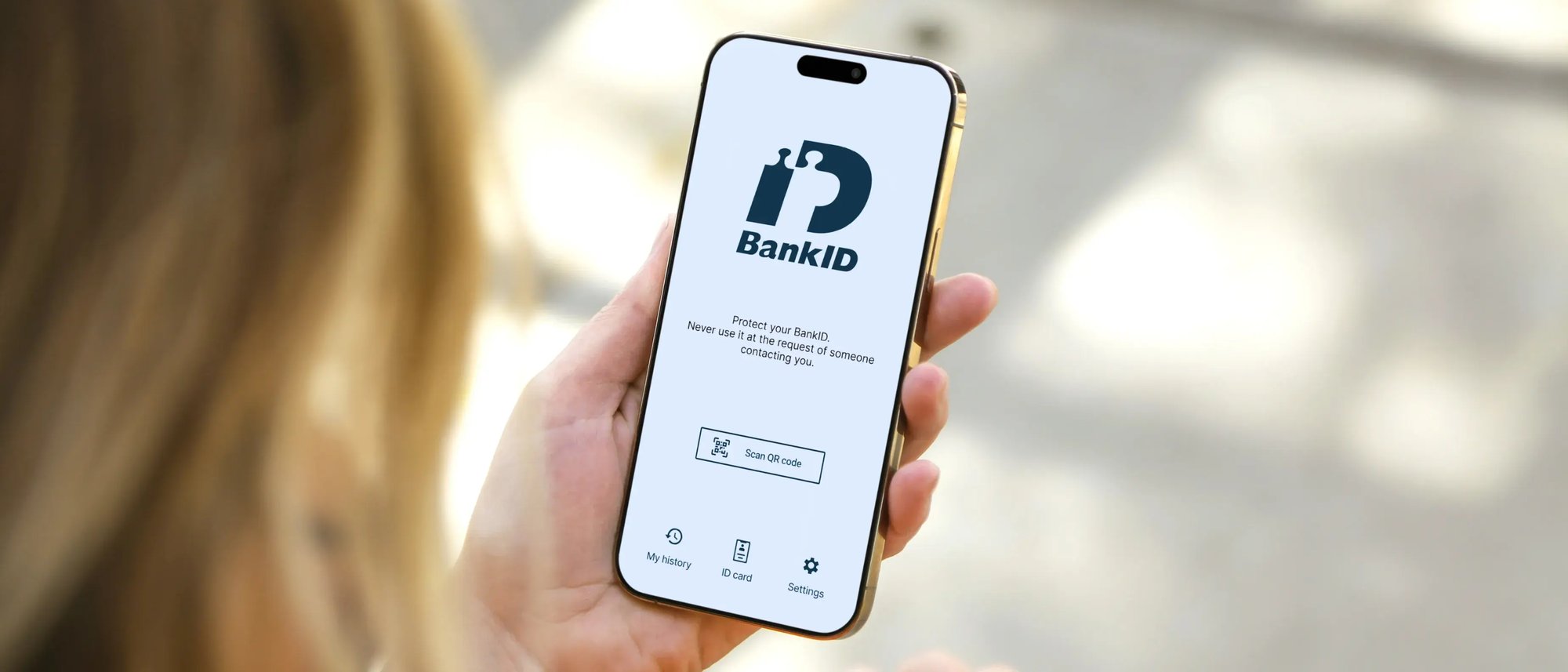 Person holding smartphone with BankID app open on screen