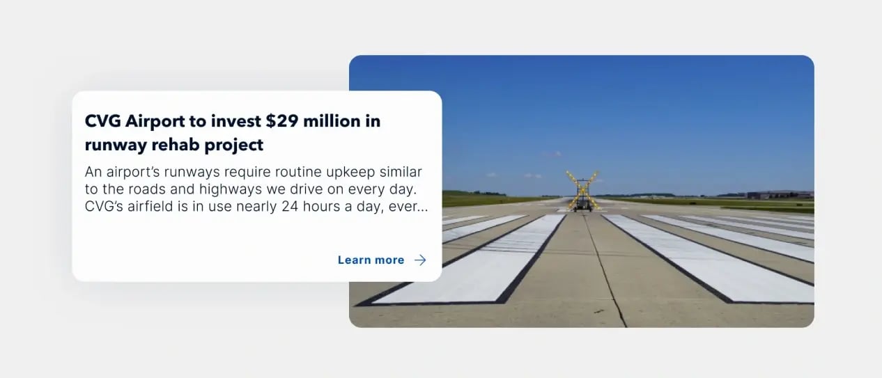 A clear, sunny view of a CVG Airport runway under maintenance, with equipment positioned at the center.