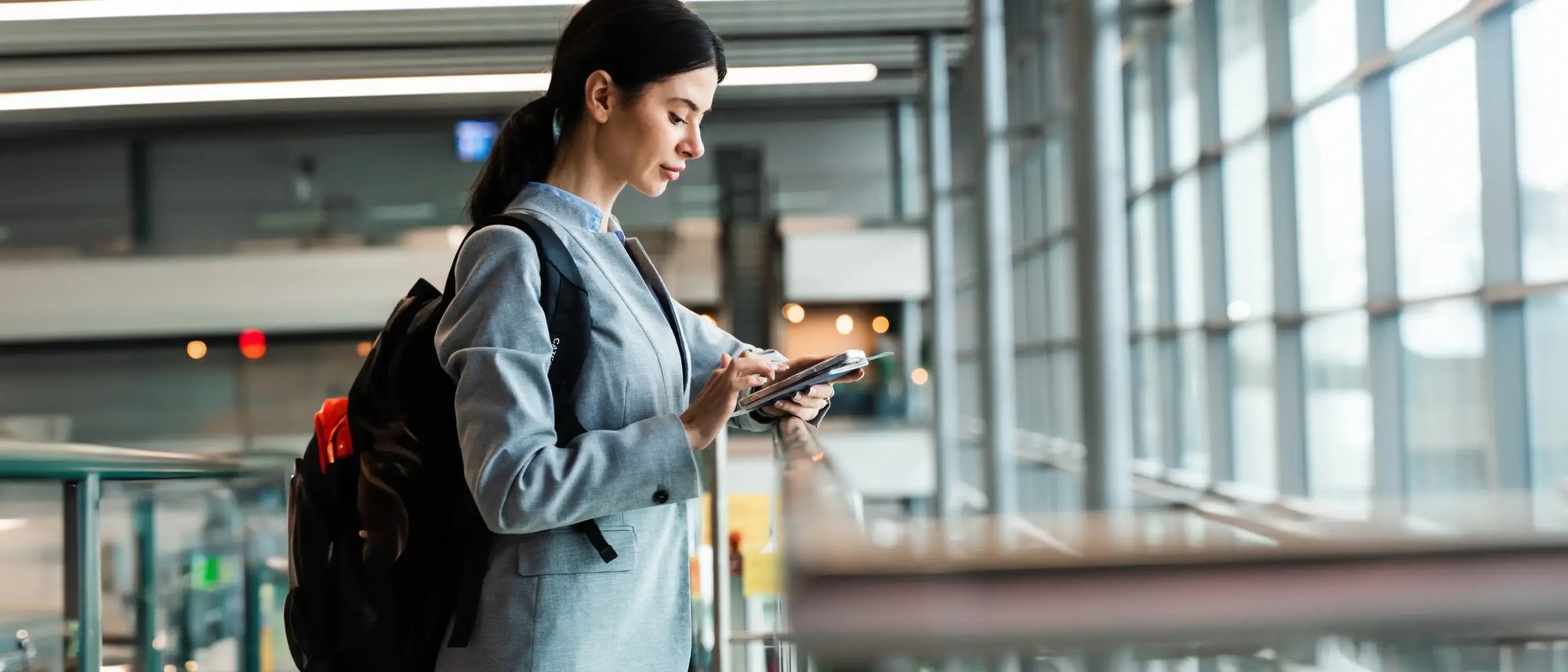 Passenger at airport using smartphone, highlighting need for 